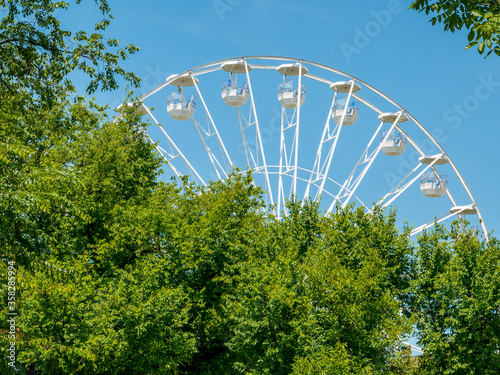 Amusement ride against blue sky. Close up with a white ferrys wheel. © Cristi