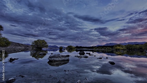 Lake with reflection of landscape and clouds.
