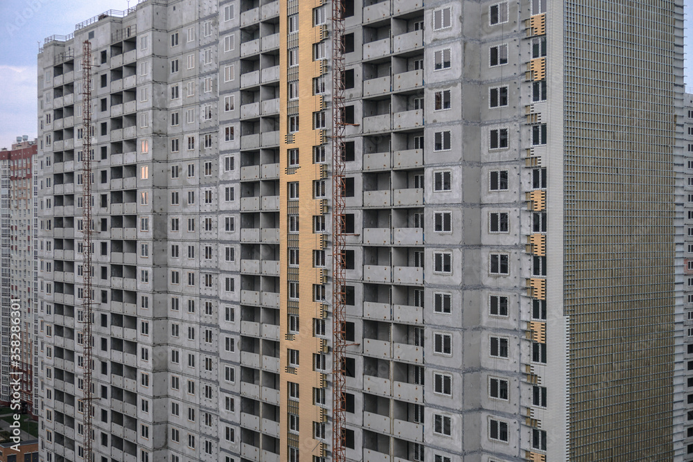 Large construction site on a background of blue sky. Brick, panel apartment building. Industrial theme for design