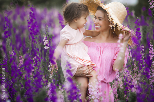 Very beautiful picture of young mother and child in the flower field photo