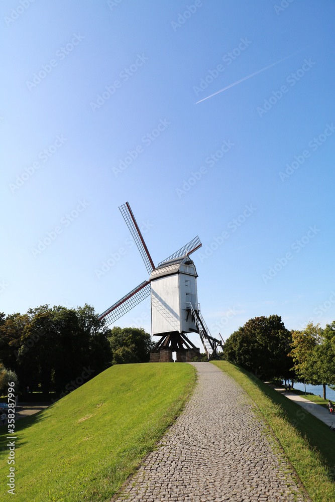 Obraz premium BRUGGE,BELGIUM AUG 12 2017 windmill with blue sky background in Brugge, Belgium.