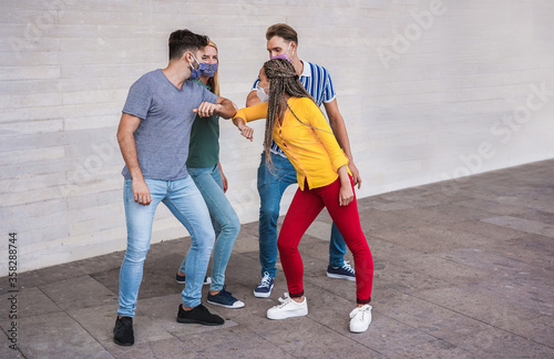 Young people friends bump their elbows instead of greeting with a hug - Avoid the spread of coronavirus, social distance and friendship concept - Main focus on left guy face