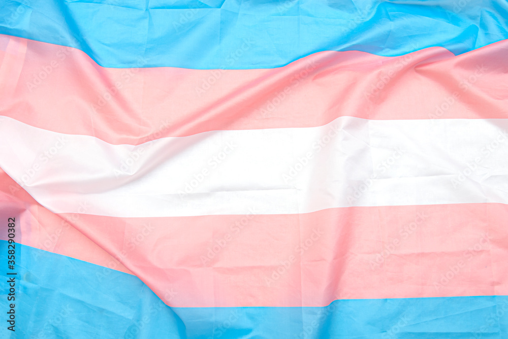 Transgender fabric flag with white, pink, blue strips. Close-up transgender pride flag as background or texture - obrazy, fototapety, plakaty 