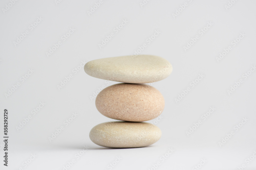 One simplicity stones cairn isolated on white background, group of light three white pebbles in tower One simplicity stones cairn isolated on white background, group of light three white pebbles in tower