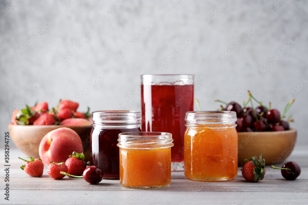 Variety of jams or preserves in glass jars. Strawberry, cherry and peach marmalade. Homemade dessert Variety of jams or preserves in glass jars. Strawberry, cherry and peach marmalade. Homemade dessert