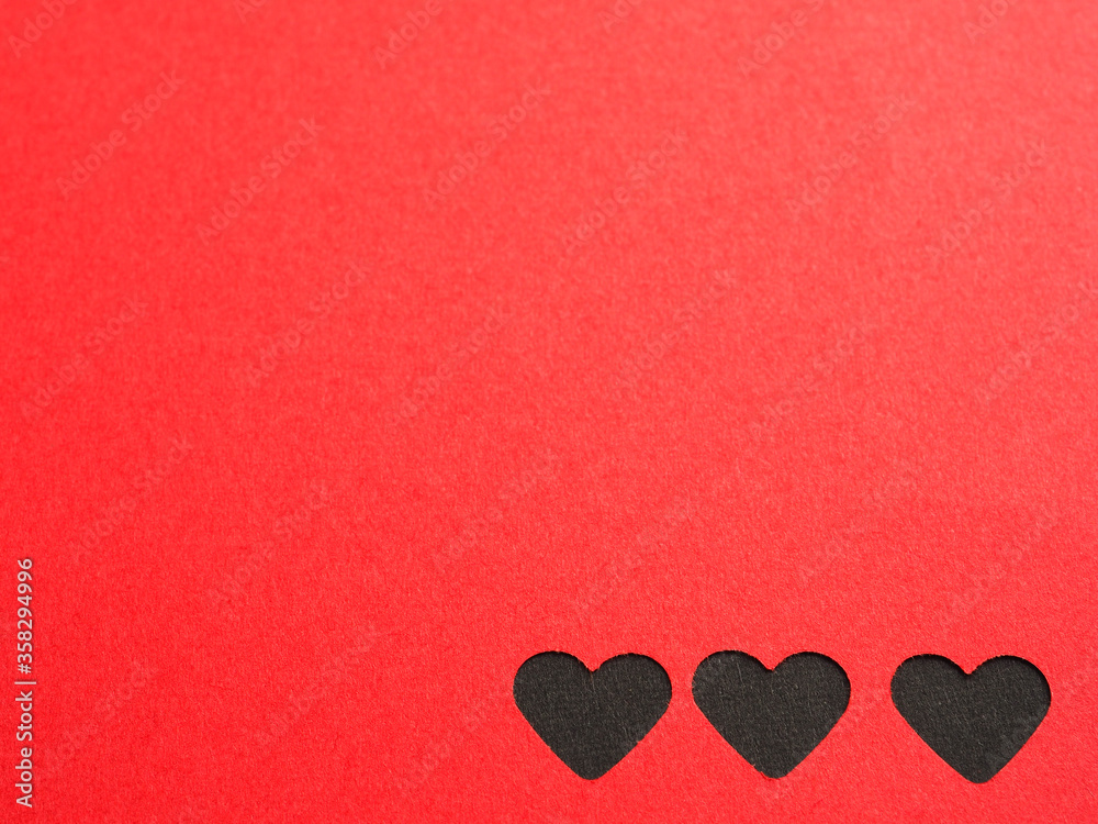 Red paper, punching in a heart shape, placed on black paper for the background of your text. The concept for design, wallpaper, love. Top view. . Red paper, punching in a heart shape, placed on black paper for the background of your text. The concept for design, wallpaper, love. Top view. .