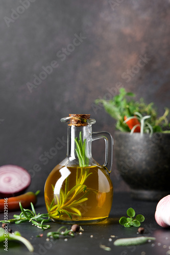Fototapeta Naklejka Na Ścianę i Meble -  Bottle of Flavored olive oil with rosemary. Traditional Mediterranean Food Ingredients