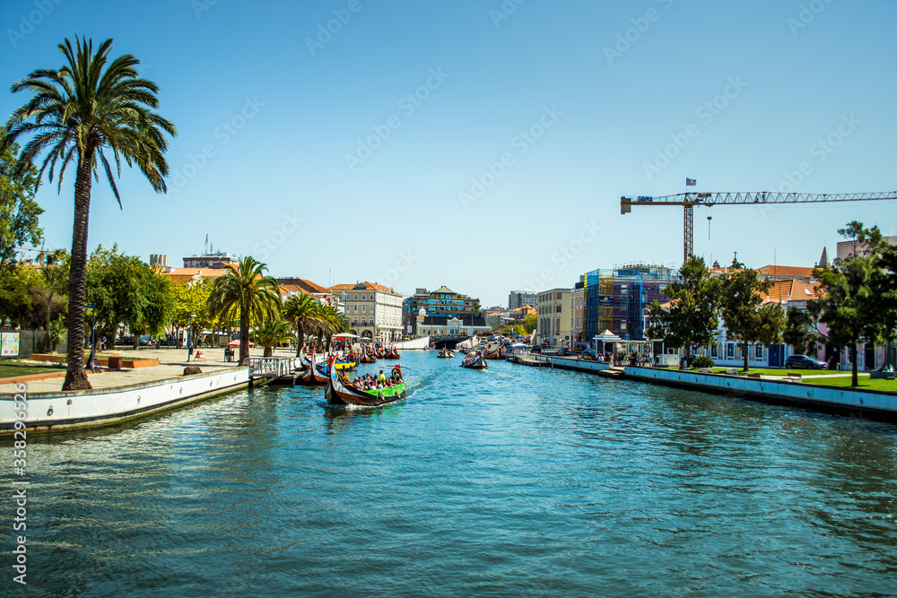 wide river that stretches in the city of Aveiro. houses over the river and clear blue water