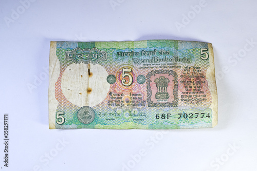 Old 5 rupees Indian currency note on white background. photo