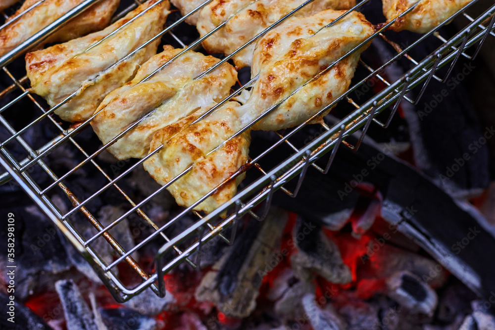 Juicy appetizing grilled chicken slices. Hot coals
