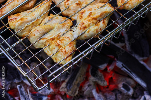 Juicy appetizing grilled chicken slices. Hot coals