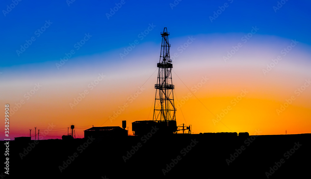 Silhouette of a drilling rig on a sunset background. A golden sunset in the Crimea.