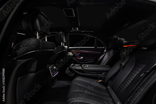 Comfortable interior of prestige modern car. Back leather seats with ambient light.