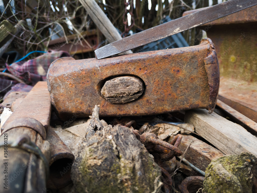 Broken rusty hammer head with rotten handle and some more rusty tools. Broken rusty hammer head with rotten handle and some more rusty tools.