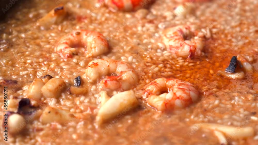 Detail of a paella of rice with prawns being cooked Detail of a paella of rice with prawns being cooked