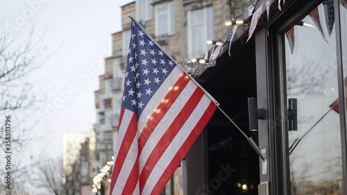 American flag on a building near the road against the background of the city. USA Symbol of power for Independence Day. Urban Temma Nu York. Stock photo photo