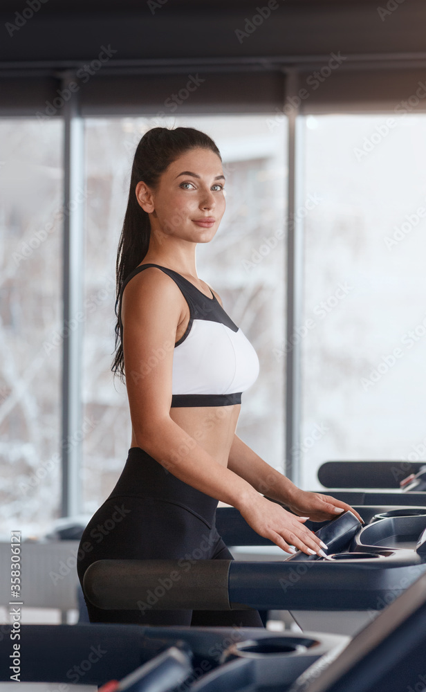 © Prostock-studio - Attractive young girl in sportswear jogging on treadmill at health club © Prostock-studio - Attractive young girl in sportswear jogging on treadmill at health club