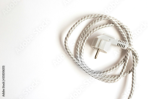 The electric plug is white. Braided cord rolled in a circle.Electric current.