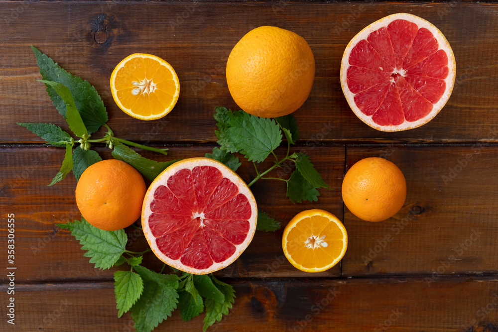 oranges and grapefruit on a brown wooden background, top view, text space, citrus oranges and grapefruit on a brown wooden background, top view, text space, citrus