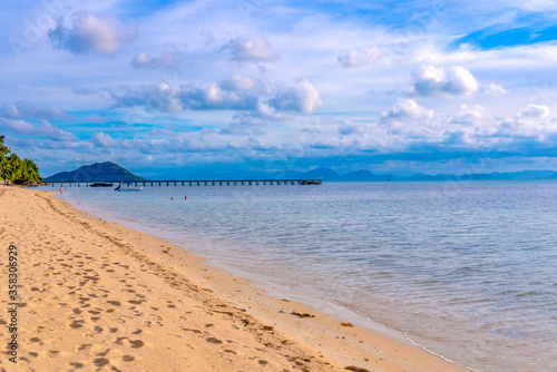 pier on the beach taling ngam of Koh Samui in Thailand, sunny beach, coconuts and palm trees, sunbathing and swimming in the sea, blue ocean and sky, travel to the resort, relaxation and enjoyment photo