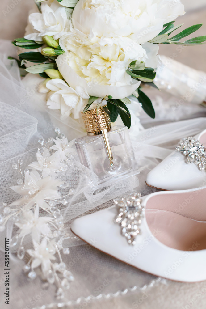 Elegant wedding accessories of an attractive bride. Wedding rings, shoes, bridal bouquet, floral arrangements, veil. Copy space for text. Background for greeting card or invitation. Elegant wedding accessories of an attractive bride. Wedding rings, shoes, bridal bouquet, floral arrangements, veil. Copy space for text. Background for greeting card or invitation.