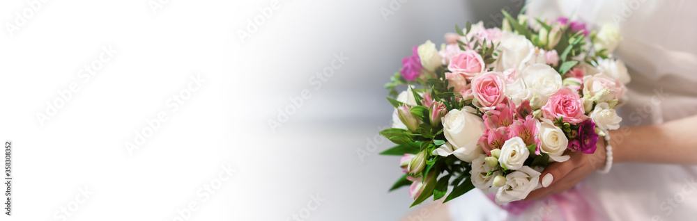 Wedding bouquet in hands of elegant bride. Copyspace with white space for text. Wedding accessories and backgrounds