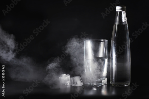 Close up pouring purified fresh drink water from the bottle on table in living room. Drinking water. Mineral vitamin water. Healthy, mineral-rich, refreshing water.