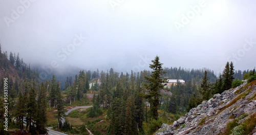 Time lapse shot of fog over trees and highway amidst mountains during winter - Mount Baker, Washington photo