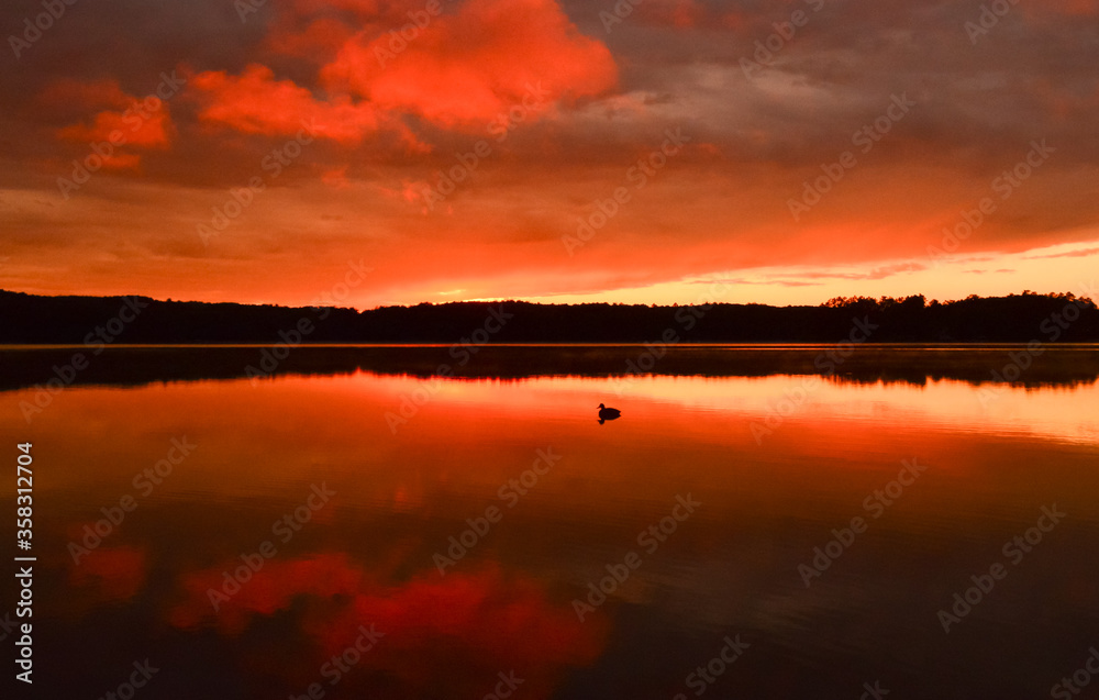 Reflection of orange sunset clouds on lake