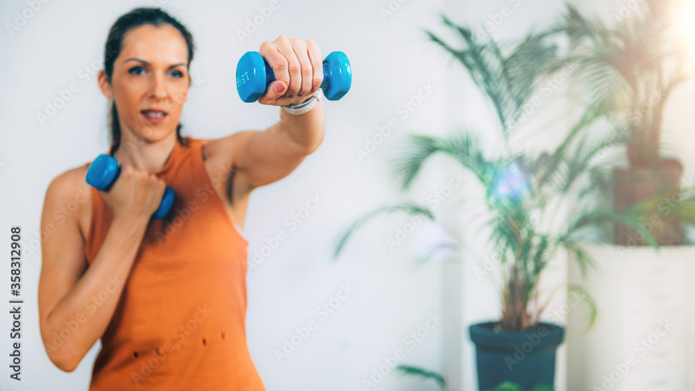 Woman Exercising with Dumbbells at Home Woman Exercising with Dumbbells at Home
