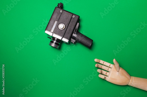 A wooden hand reaches out to the camera on a background of a green background. Video production. Hromakey. copy space photo