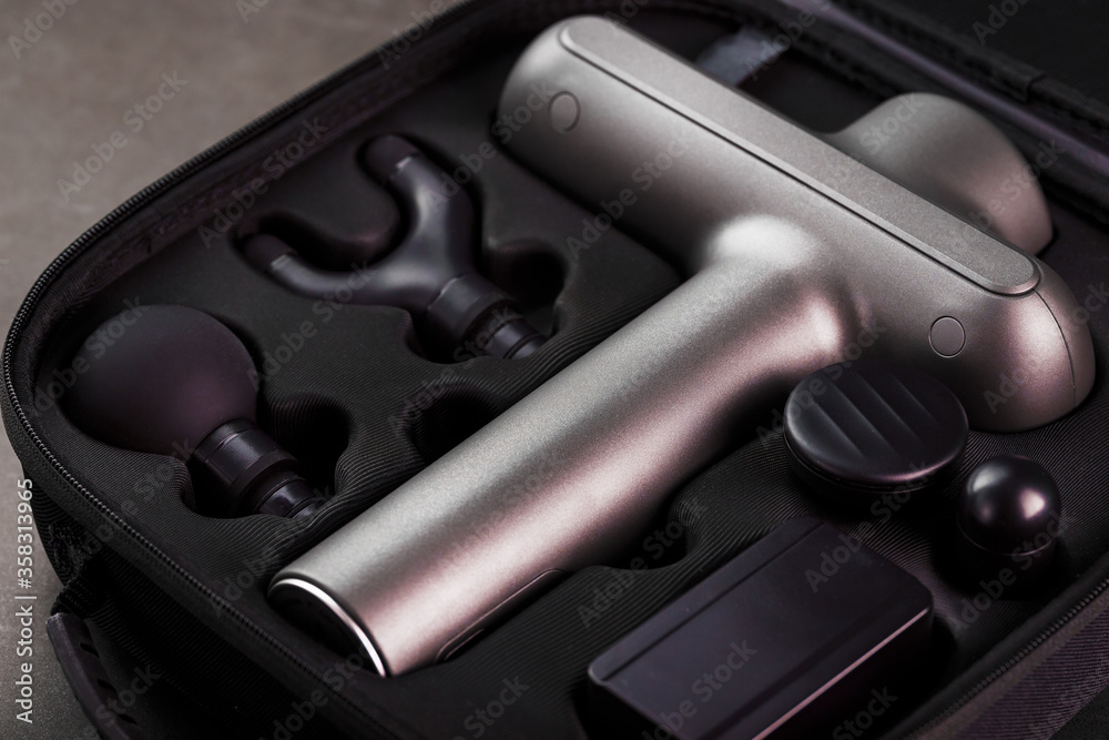 Obraz premium Electric massager Machine for body massage in a case on a black background.