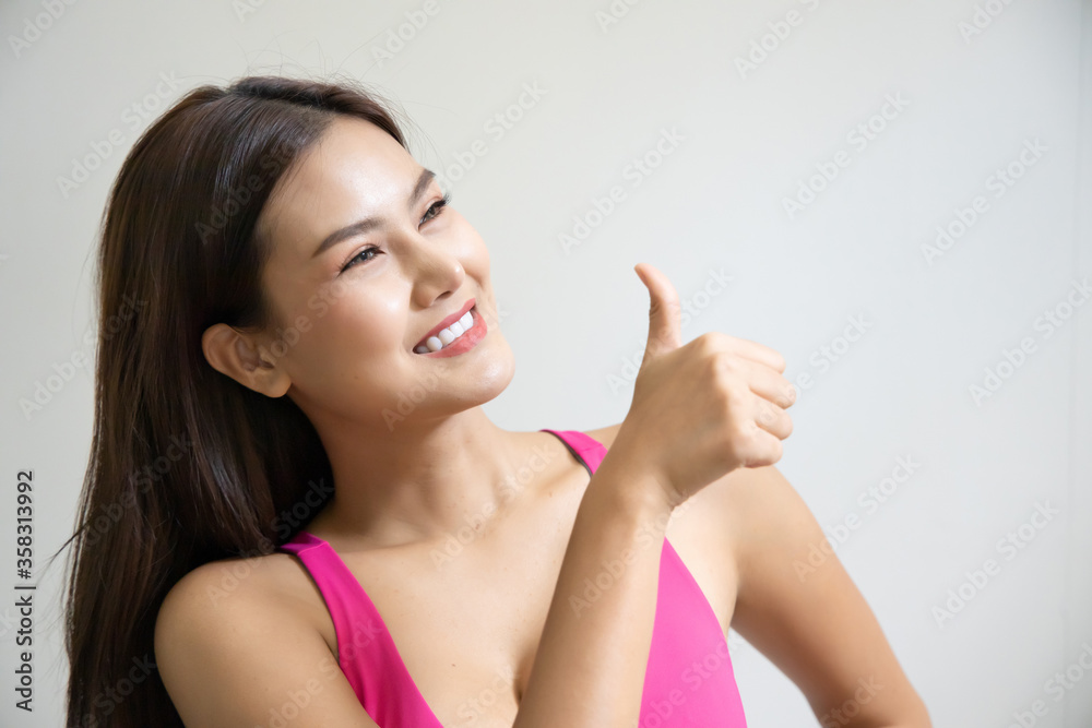 successful girl pointing thumb up; portrait of cheerful smiling woman pointing up approving, yes, ok, good, thumb up gesture; southeast asian woman young adult model successful girl pointing thumb up; portrait of cheerful smiling woman pointing up approving, yes, ok, good, thumb up gesture; southeast asian woman young adult model