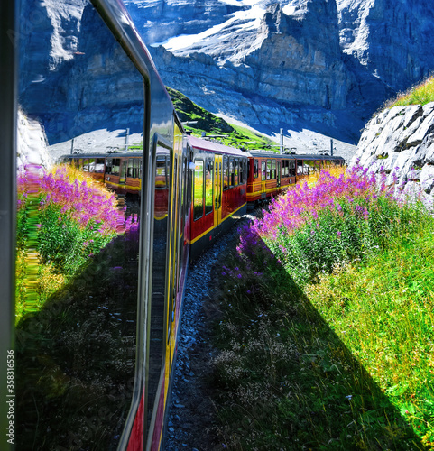 Beautiful scenery with cogwheel red train of the famous Jungfrau Railway from Jungfraujoch ( Top of Europe) to Kleine Scheidegg, Bernese Oberland, Switzerland photo