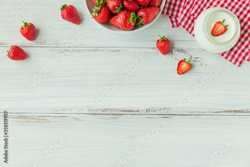 Fresh strowberries on ceramic bowl top view. Healthy food on white wooden table mockup. Delicious, sweet, juicy and ripe berry bacgroung photo