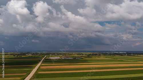 Storm above a agricultural plain  country road