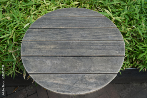 Empty of wood table top on fresh green grasses abstract background with tilt shifting focus. For montage product display or design key visual layout