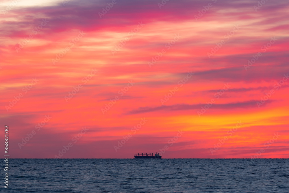 Obraz premium Horizon's Edge: Minimalistic Sunrise Seascape with a Ship
