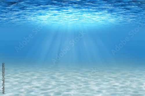 Ocean underwater scene with sandy seabed and light rays. Blue decorative background.