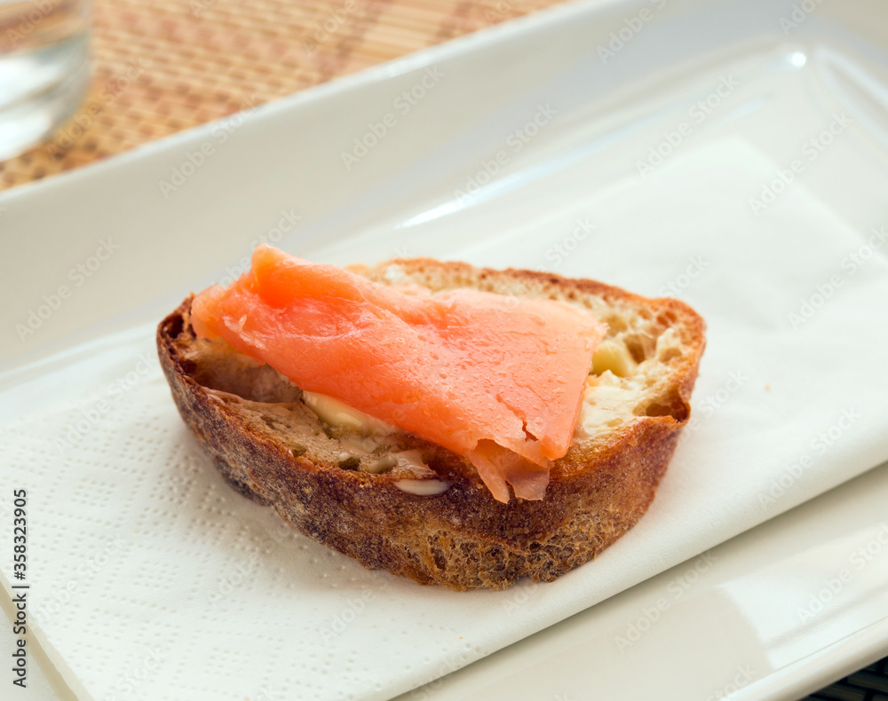 delicious canapes of salted, smoked salmon fillet on slice of fresh ciabatta bread delicious canapes of salted, smoked salmon fillet on slice of fresh ciabatta bread