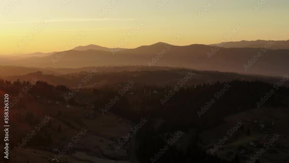Sunset in the Carpathian mountains in golden time on the background of the old settlement of Hotsuls. Shooting from a drone. Sunset in the Carpathian mountains in golden time on the background of the old settlement of Hotsuls. Shooting from a drone.
