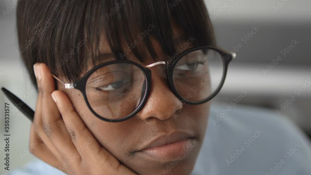 Sleepy black female sitting in office, overworked at stressful job, burnout Sleepy black female sitting in office, overworked at stressful job, burnout