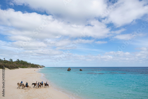 Fototapeta Naklejka Na Ścianę i Meble -  Bermuda beach with horseback riders in the distance