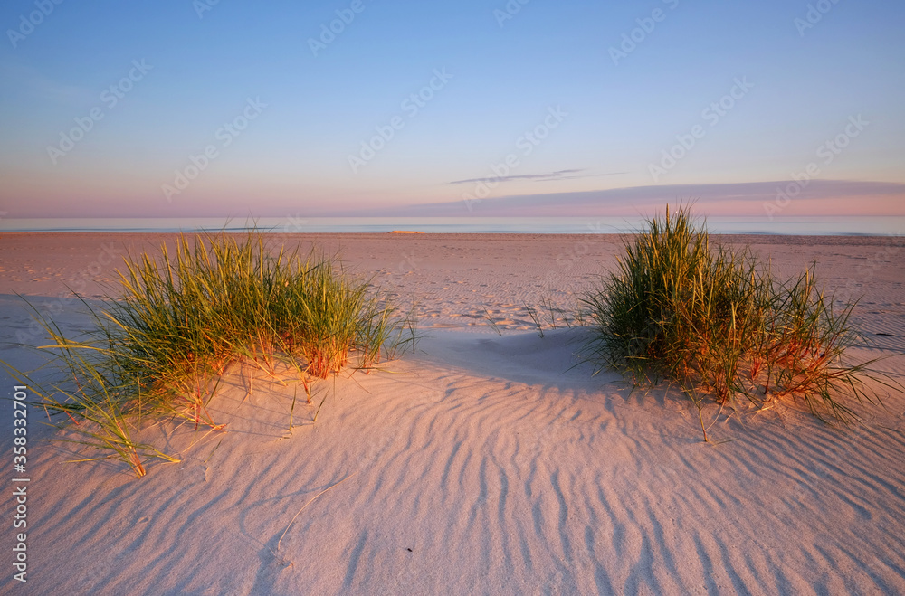 Morze Bałtyckie,wschód słońca na piaszczystej plaży w Kołobrzegu,Polska.
