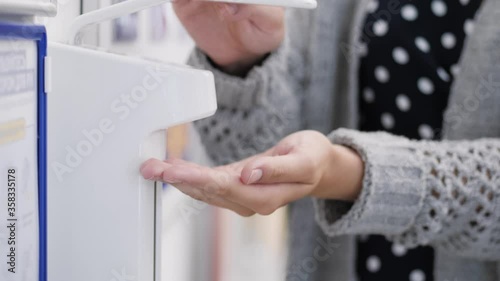 Wallpaper Mural Woman disinfects her hand in supermarket. Close-up Torontodigital.ca