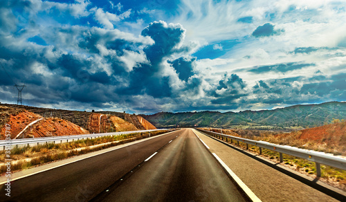 Carretera de asfalto vacía y cielo nublado de tormenta. Pintoresco paisaje de carretera y el amanecer sobre la curva de la carretera