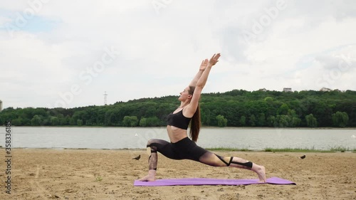 Woman doing yoga exercise on the sand beach
