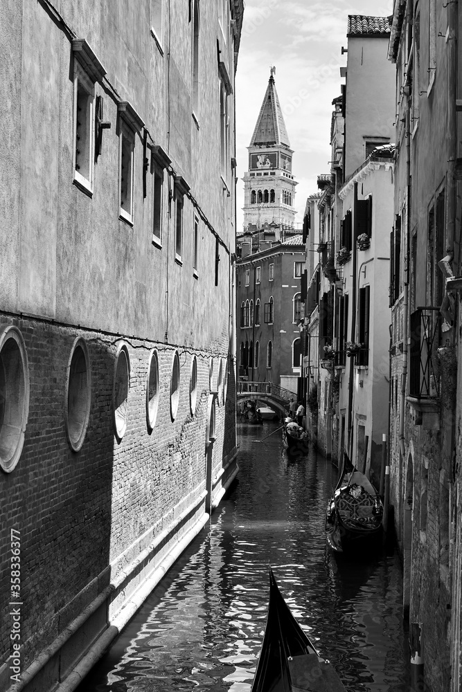 Fototapeta premium Narrow canal with gondolas in Venice