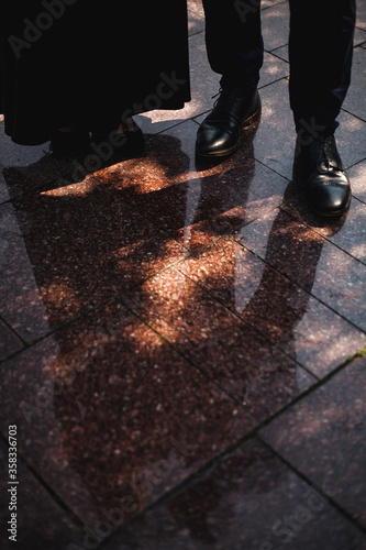 Reflection of a couple in the water. Elegant shoes in focus 