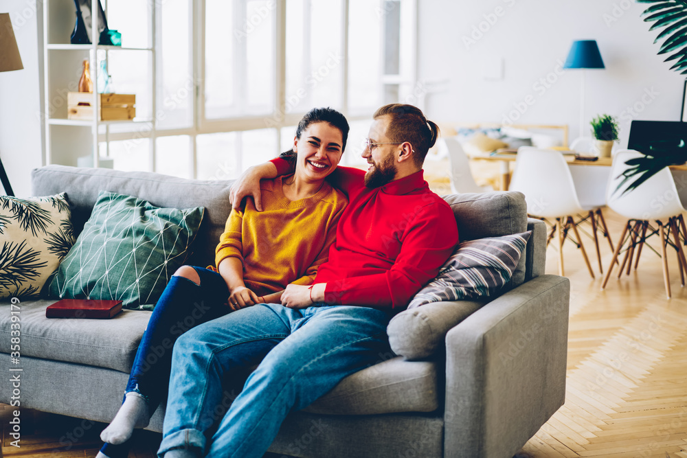 Emotional romantic couple feeling happiness resting in cozy home interior,young marriage satisfied with getting new apartments for living sitting at comfortable sofa